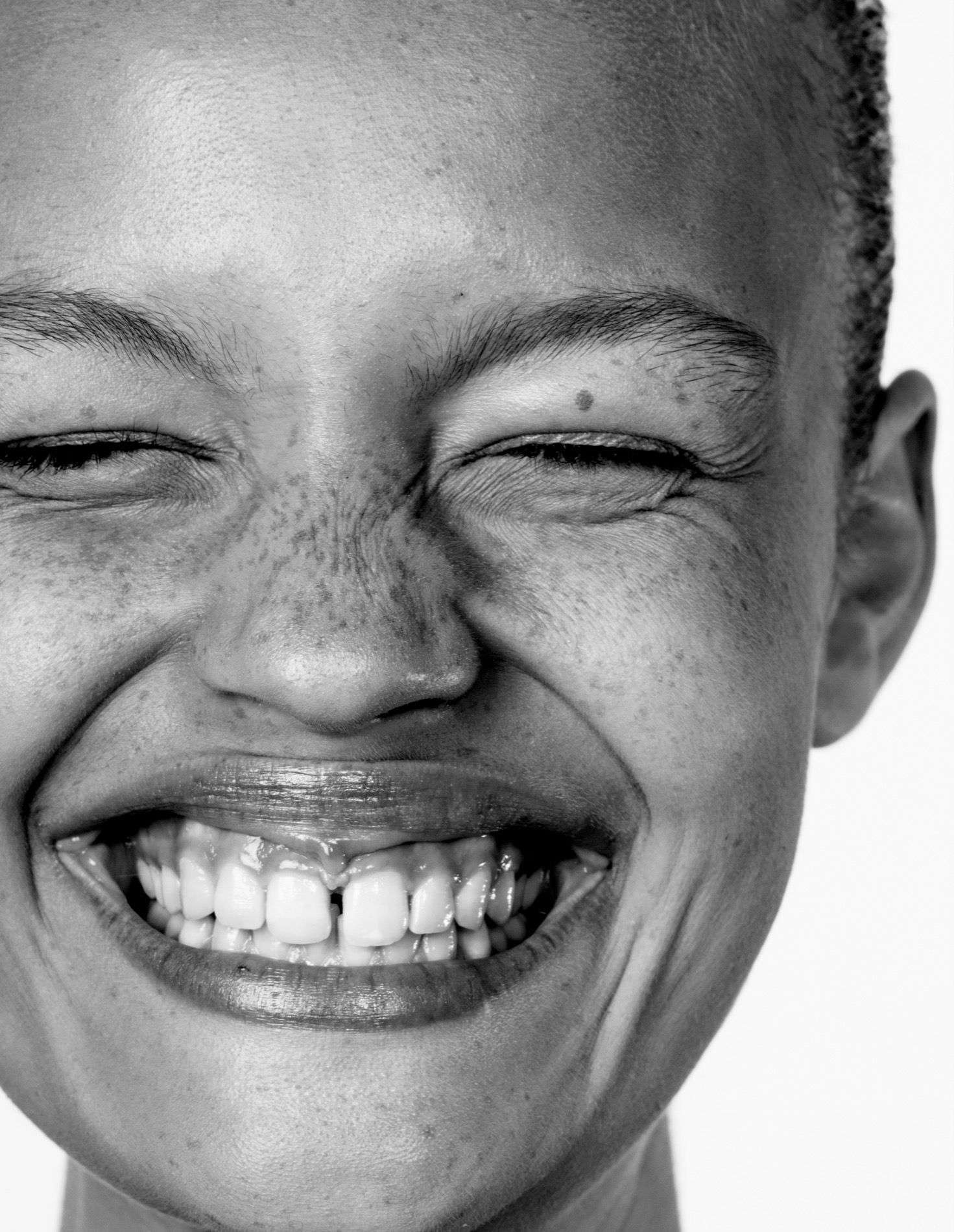 Beauty editorial in black-and-white, laughing face with freckles